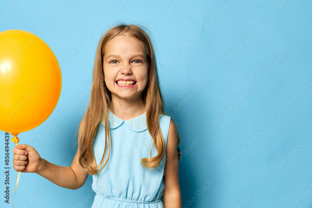 Cheerful little girl holding a bright yellow balloon against a vibrant blue background, capturing the joy of childhood Cheerful little girl holding a bright yellow balloon against a vibrant blue background, capturing the joy of childhood