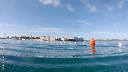 Swimming in warm blue Adriatic with city panorama of Zadar in the background, Croatia in the morning