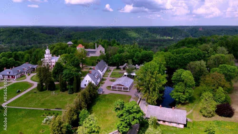 Aerial View Of Neo-Gothic Sigulda New Castle With Tower And Lush Nature Background In Latvia. Aerial View Of Neo-Gothic Sigulda New Castle With Tower And Lush Nature Background In Latvia.
