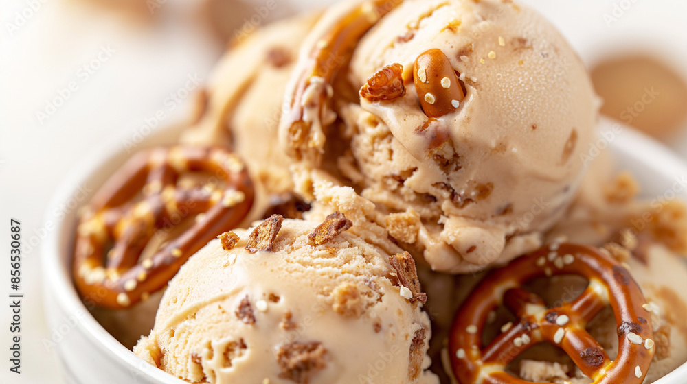 Decadent salted caramel and pretzel ice cream, a closeup of decadent salted caramel and pretzel ice cream, its rich color and bits of pretzel against a white background Decadent salted caramel and pretzel ice cream, a closeup of decadent salted caramel and pretzel ice cream, its rich color and bits of pretzel against a white background