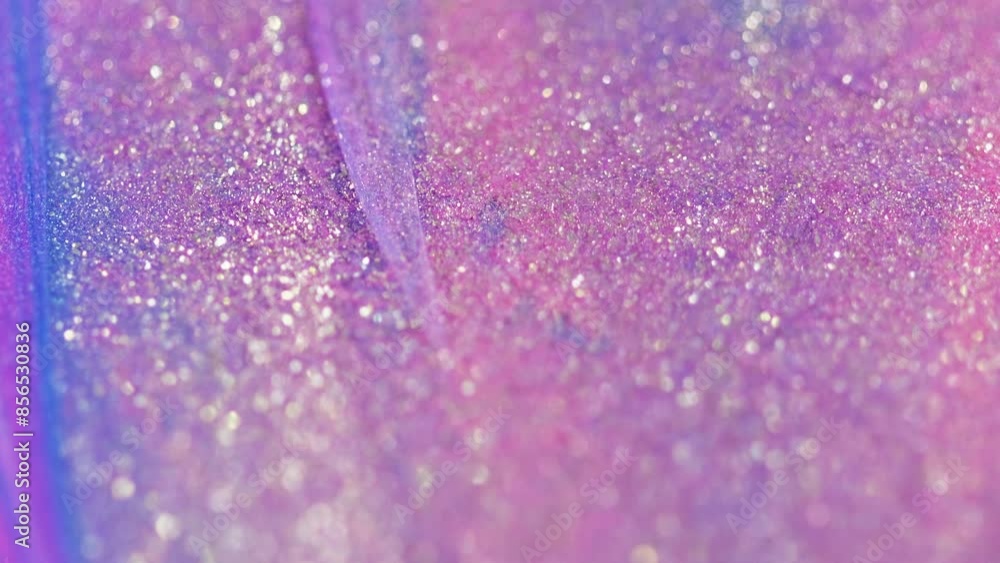 Shiny paint drip. Glitter fluid texture. Defocused pink purple color sparkle particles wet glow ink liquid gloss spill wave motion abstract art background with bokeh lights. Shiny paint drip. Glitter fluid texture. Defocused pink purple color sparkle particles wet glow ink liquid gloss spill wave motion abstract art background with bokeh lights.