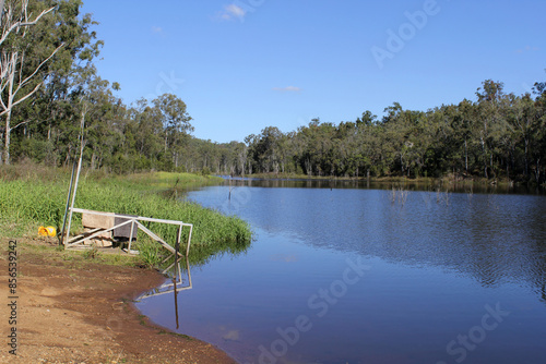 Peaceful scene of water and a forest of trees and grass at Lake Monduran in Queensland, Australia photo