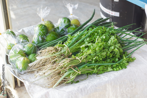 Vegetables on the tray for sale such as  lime, spring onions, coriander, shallots for sale in Thailand