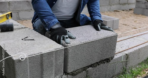 Construction worker laying expanded clay blocks. Foundations of a house, the frame of a new house in the process of construction