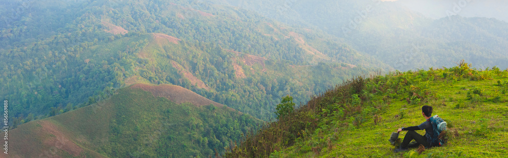 Traveler men with backpack walking on path in the tropical forest. Web banner size. Traveler men with backpack walking on path in the tropical forest. Web banner size.
