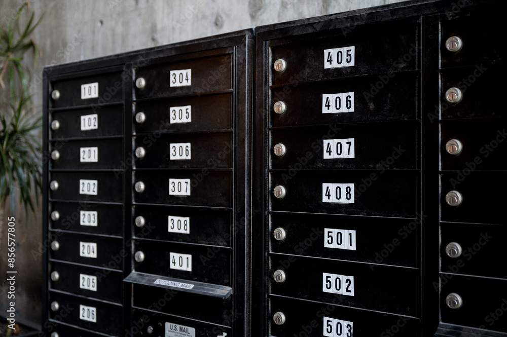 rows of black metal apartment complex mailboxes. Each box is labeled with numbers and has a lock. rows of black metal apartment complex mailboxes. Each box is labeled with numbers and has a lock.