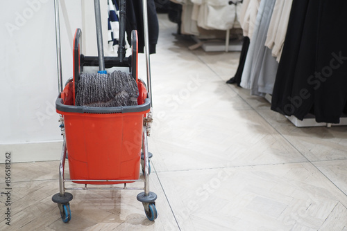 A gaspowered cleaning machine with a rolling cart, broom, and mop photo