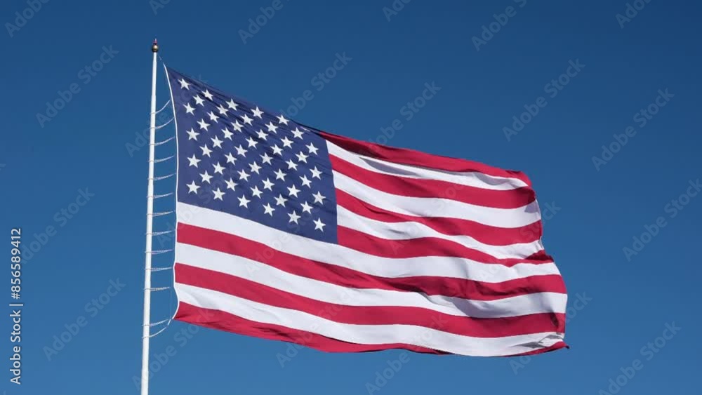 Slow motion American flag waving against a blue sky background Slow motion American flag waving against a blue sky background