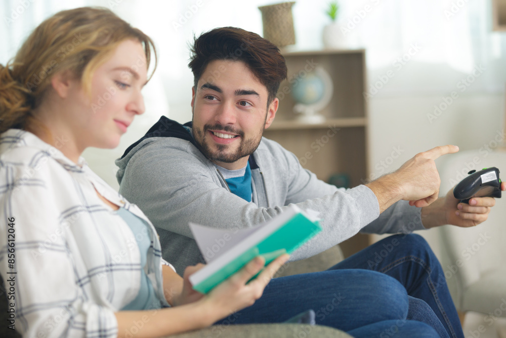 Fototapeta premium woman ignoring boyfriend while she reads a book