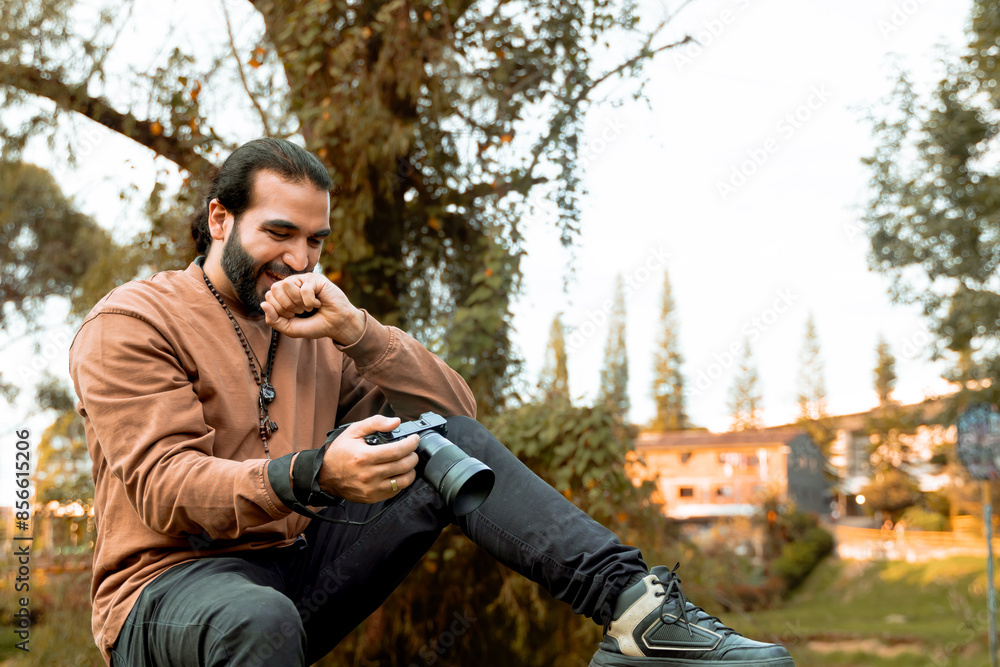 Long-haired, bearded Latino man in a brown jacket documenting his holiday and enjoying the golden hour in his country. World photography and travel day. Long-haired, bearded Latino man in a brown jacket documenting his holiday and enjoying the golden hour in his country. World photography and travel day.
