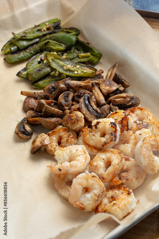 A view of roasted ingredients for shrimp fajitas, featuring mushrooms and jalapenos. A view of roasted ingredients for shrimp fajitas, featuring mushrooms and jalapenos.