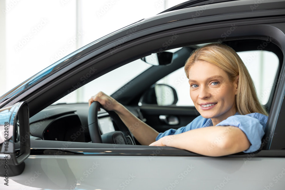 Waist up of a smiling woman sitting in a car Waist up of a smiling woman sitting in a car