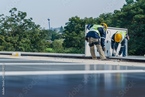 Worker Technicians are working to construct solar panels system on roof. Installing solar photovoltaic panel system. Men technicians carrying photovoltaic solar modules on roof. © ultramansk