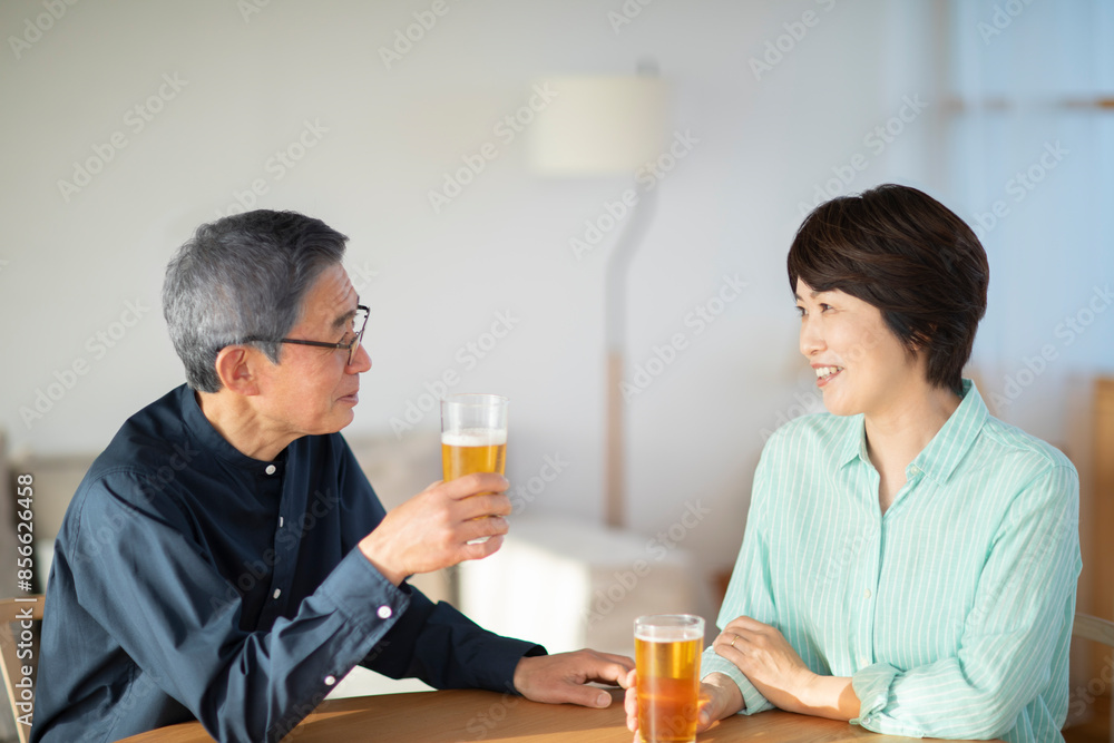 リビングでビールを飲みながら話すシニア夫婦