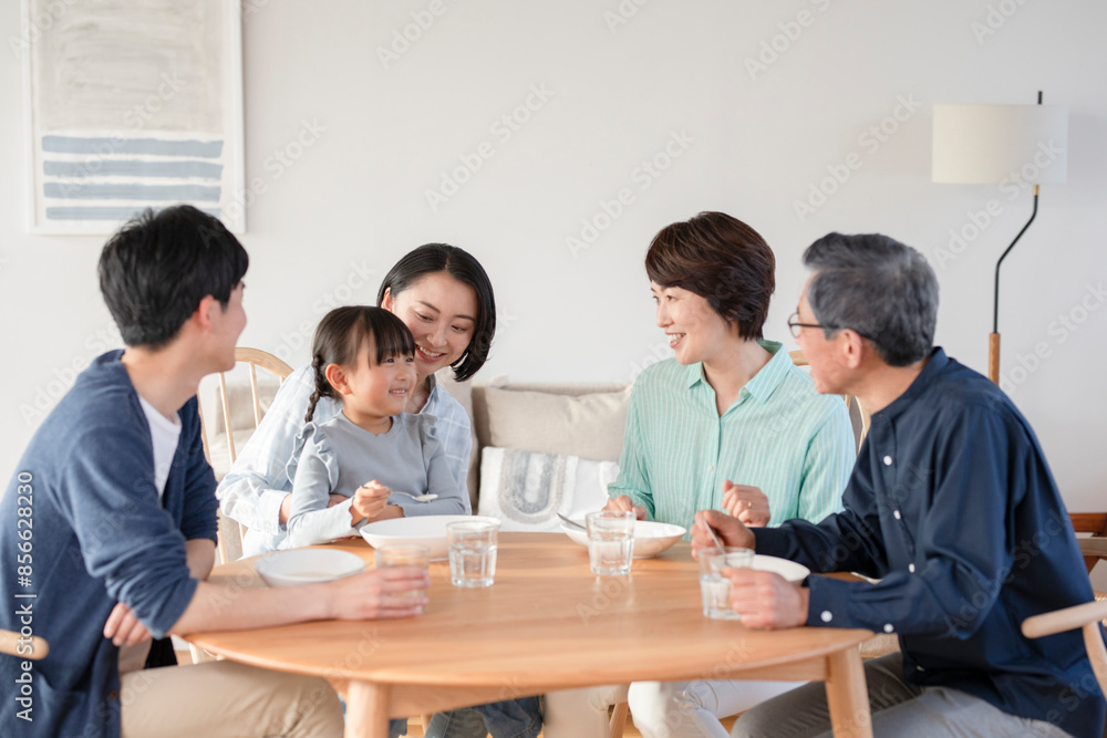 リビングで食事する三世代家族