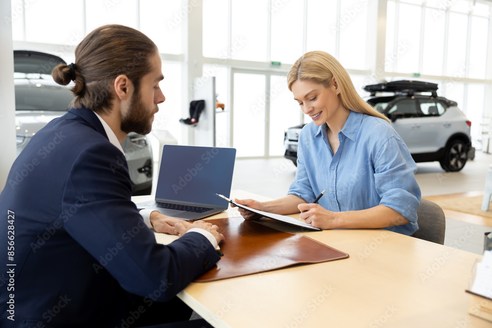 Male sale assistant talking to a female customer in a dealership Male sale assistant talking to a female customer in a dealership