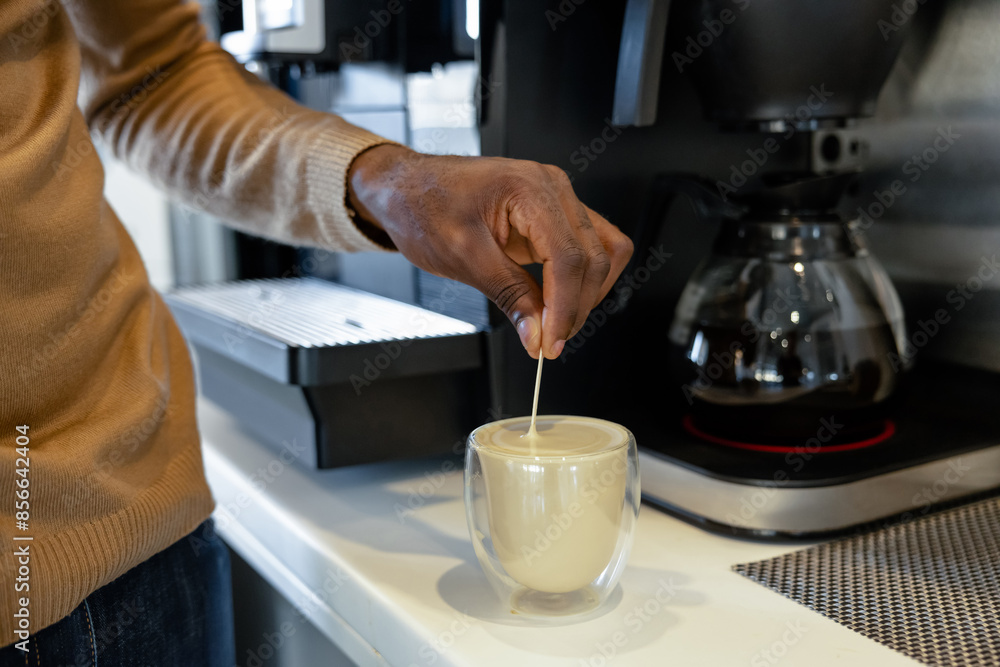 Unrecognizable man worker taking break to prepare coffee in the office kitchen Unrecognizable man worker taking break to prepare coffee in the office kitchen