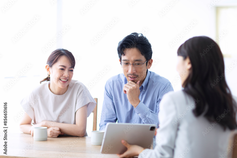 タブレット端末を持つスーツを着た女性と夫婦