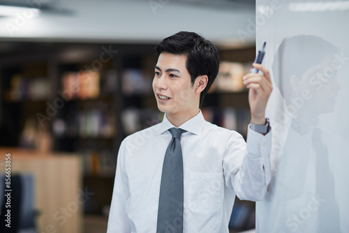 ホワイトボードを使い会議をするビジネスマン