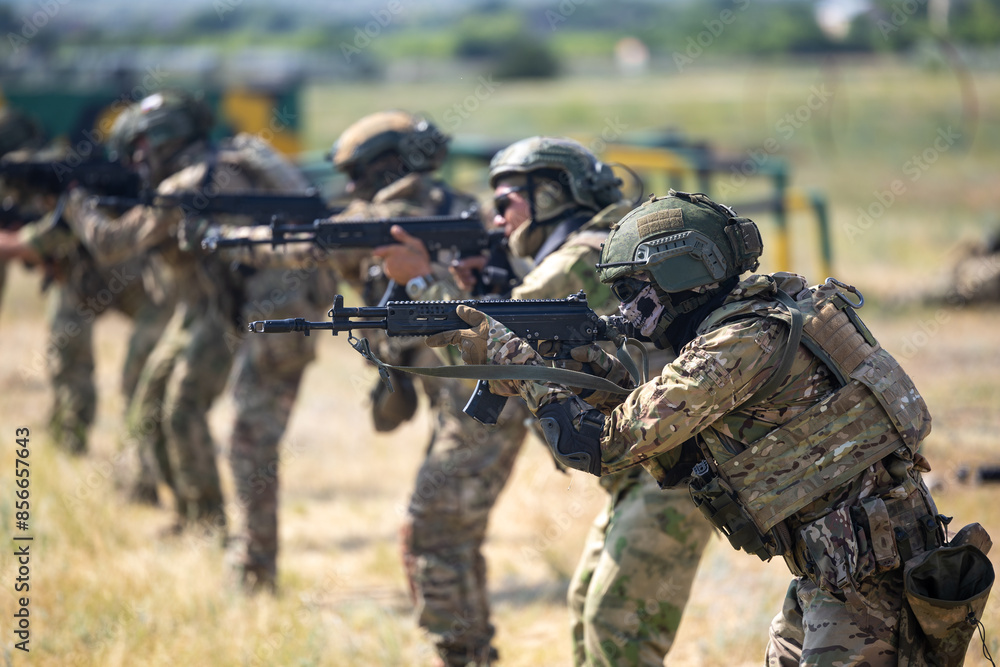 Fototapeta premium Army soldier with a machine gun in his hand. Soldier, commando stands, ready for combat training. Military fashion. Army attack enemy soldier in military uniform.