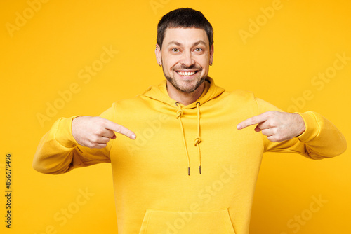Young happy smiling shocked cheerful surprised Caucasian man he wears hoody casual clothes point index finger on himself isolated on plain yellow orange background studio portrait. Lifestyle concept.