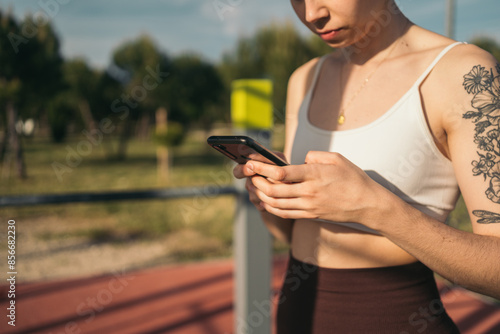 Fitness enthusiast checking smartphone outdoors