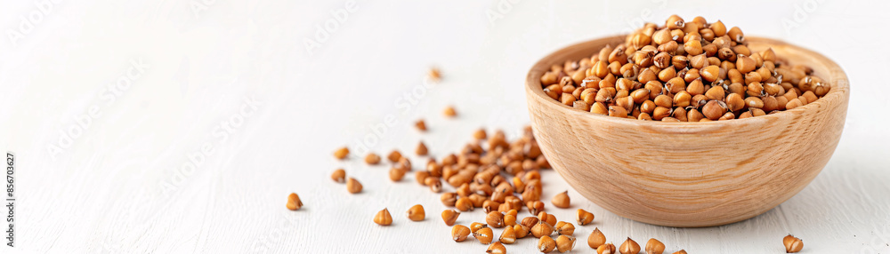 Buckwheat groats in a wooden bowl on a white background. Buckwheat groats in a wooden bowl on a white background.
