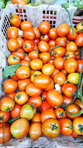 a pile of red tomatoes being sold at the market
