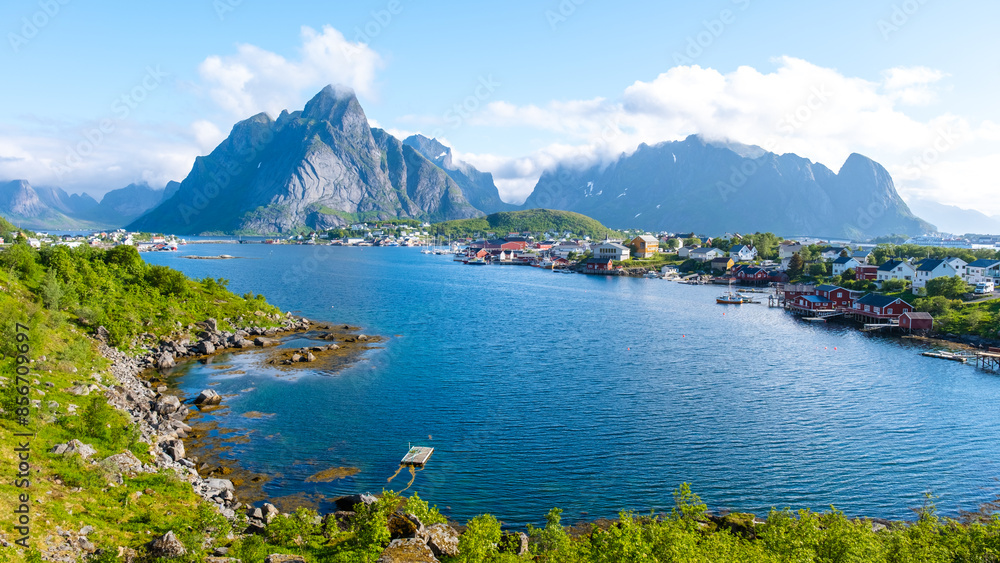 Fototapeta premium Norwegian fjord view with mountains, calm waters, and a quaint village. The scenery embodies the beauty and serenity of Norway. Reine, Lofoten, Norway