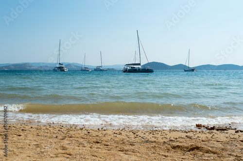 Sailboats anchored near the sandy beach, summer vacation, in Vrgada, near Pakostane, Croatia photo