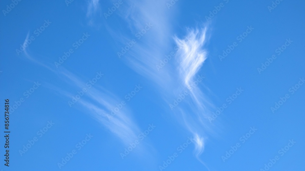 Clear blue sky with unusual white clouds, nature background, painted sky, natural template