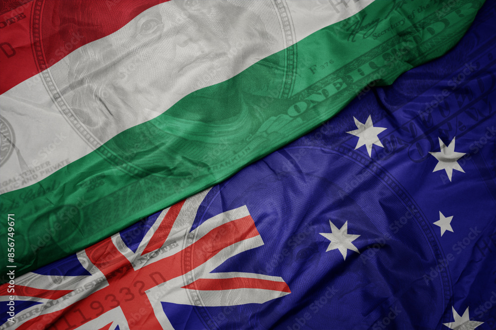 waving colorful flag of hungary and national flag of australia on the dollar money background. finance concept. waving colorful flag of hungary and national flag of australia on the dollar money background. finance concept.