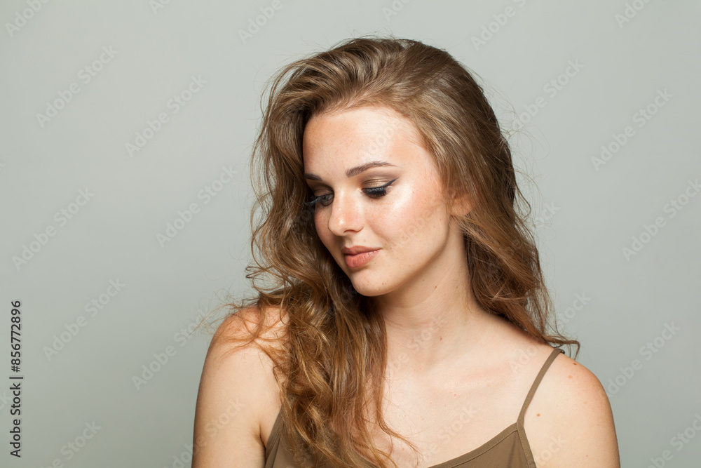 Stylish young lady with makeup and long wavy hair, closeup portrait. Beautiful woman Stylish young lady with makeup and long wavy hair, closeup portrait. Beautiful woman
