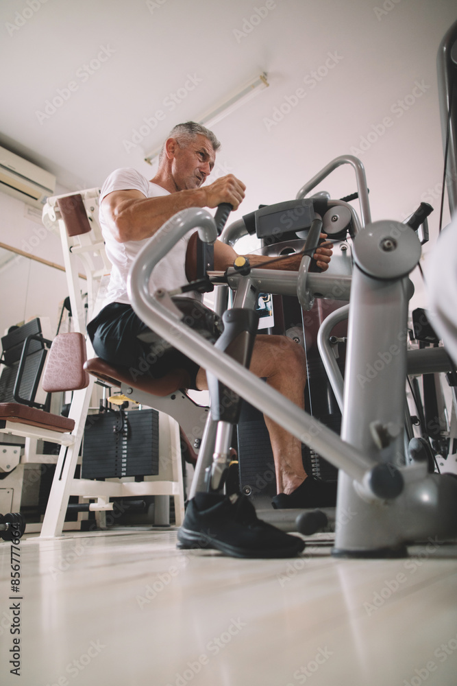 Obraz premium Veteran amputee athlete exercising in gym 