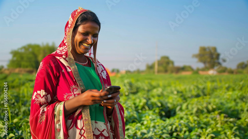 Indian female woman farmer in traditional attire, holding a smarphone