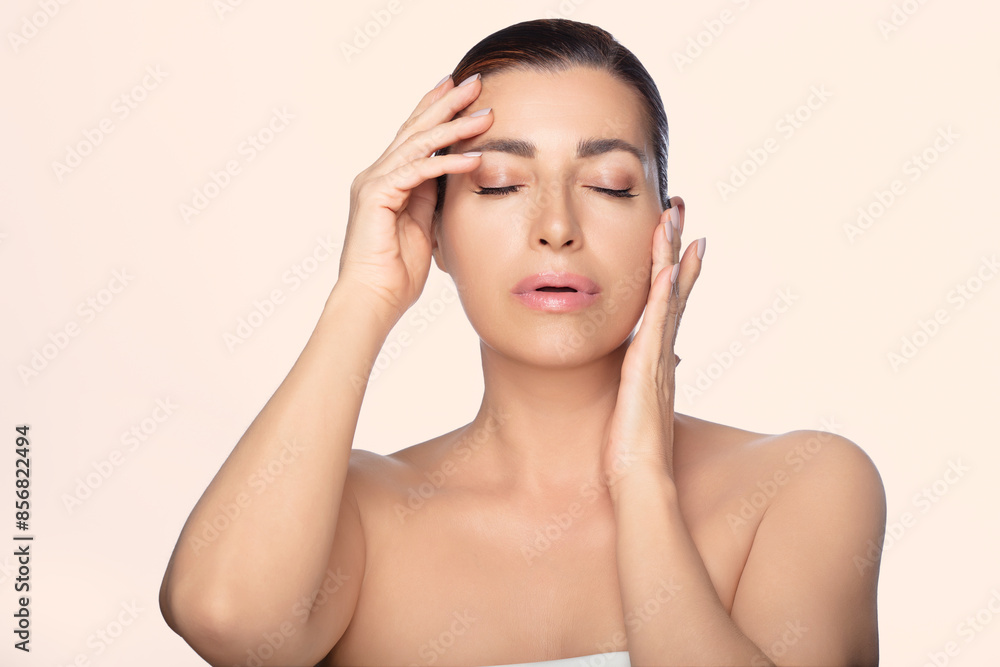 Natural beauty skincare concept with gorgeous mid-aged woman posing in a serene expression Natural beauty skincare concept with gorgeous mid-aged woman posing in a serene expression