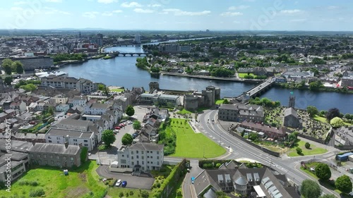 King John's Castle, Limerick, Ireland, May 2024. Drone orbits the Medieval Castle on the banks of the River Shannon with St Munchin's church and Jones Mausoleum in the foreground. photo