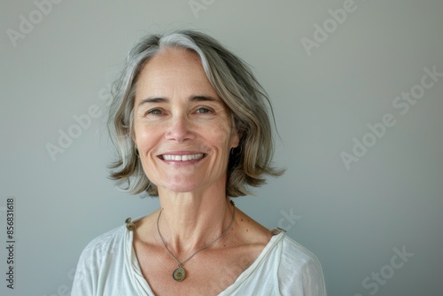 Portrait of a content caucasian woman in her 60s smiling at the camera isolated in plain white digital canvas