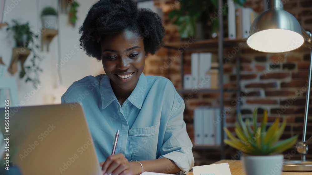 Smiling young black female staying late in office image copy space. African american woman at laptop banner background blurred. Career development concept photography copyspace Smiling young black female staying late in office image copy space. African american woman at laptop banner background blurred. Career development concept photography copyspace