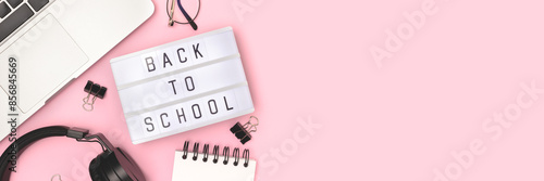 Back to school. Banner with lightbox, headphones, laptop and stationery on a pink background.