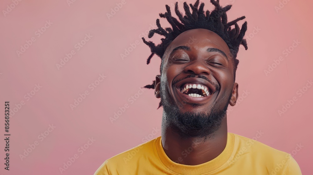 Man with dreadlocks laughs against a pink wall Man with dreadlocks laughs against a pink wall