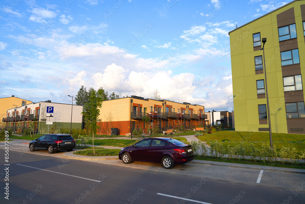 Modern European complex of apartment buildings. Street in New modern housing estate. Twin house at road in Urbanization. Finished new townhouses. Еxterior townhomes. Car on parking lot at Townhouse. Modern European complex of apartment buildings. Street in New modern housing estate. Twin house at road in Urbanization. Finished new townhouses. Еxterior townhomes. Car on parking lot at Townhouse.