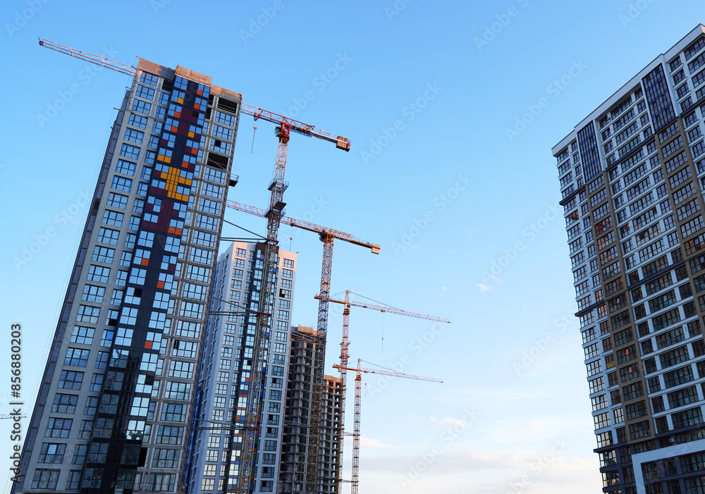 Building construction. High-rise residential building construction. Tower cranes on Skyscraper construction. Modern facade building and housing. Buildings architecture. Urban Skyline Skyscrapers. Building construction. High-rise residential building construction. Tower cranes on Skyscraper construction. Modern facade building and housing. Buildings architecture. Urban Skyline Skyscrapers.