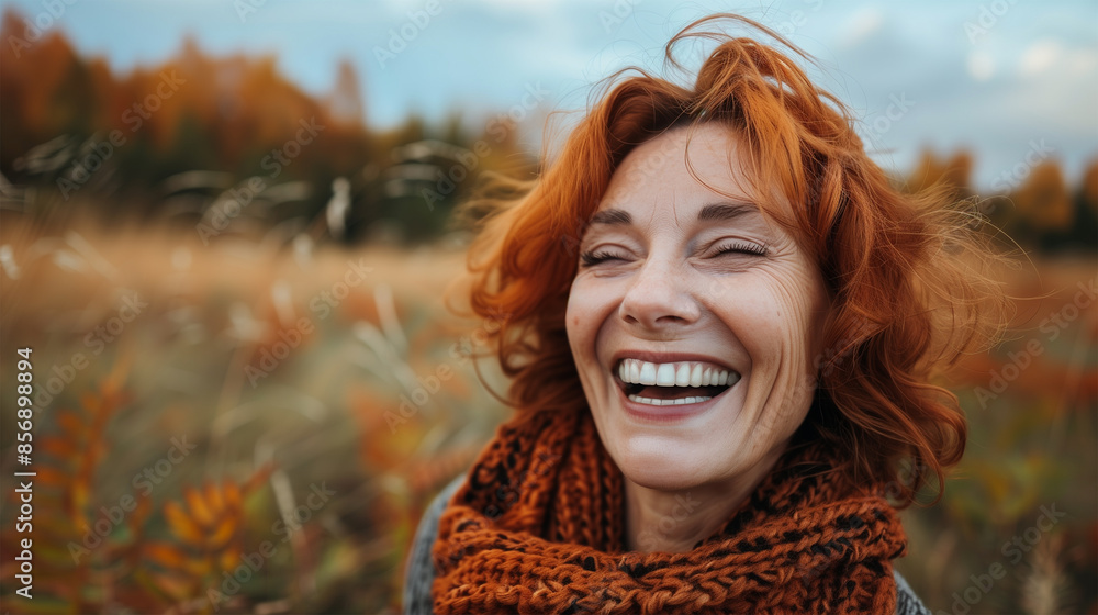 Portrait of a Joyful Mature Red-haired Woman on an Autumnal Stroll, Smiling Middle-Aged Woman in an Outdoor Setting with Multicolored Autumnal Leaves. Portrait of a Joyful Mature Red-haired Woman on an Autumnal Stroll, Smiling Middle-Aged Woman in an Outdoor Setting with Multicolored Autumnal Leaves.