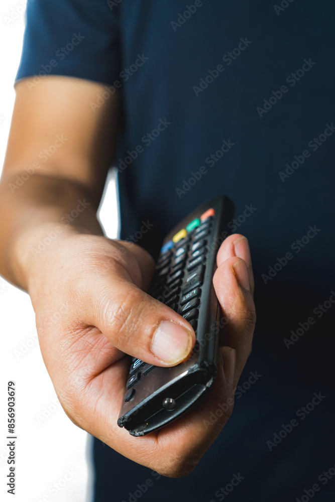 Fototapeta premium A man's holds and presses the button of an broken and old TV remote, isolated on white background