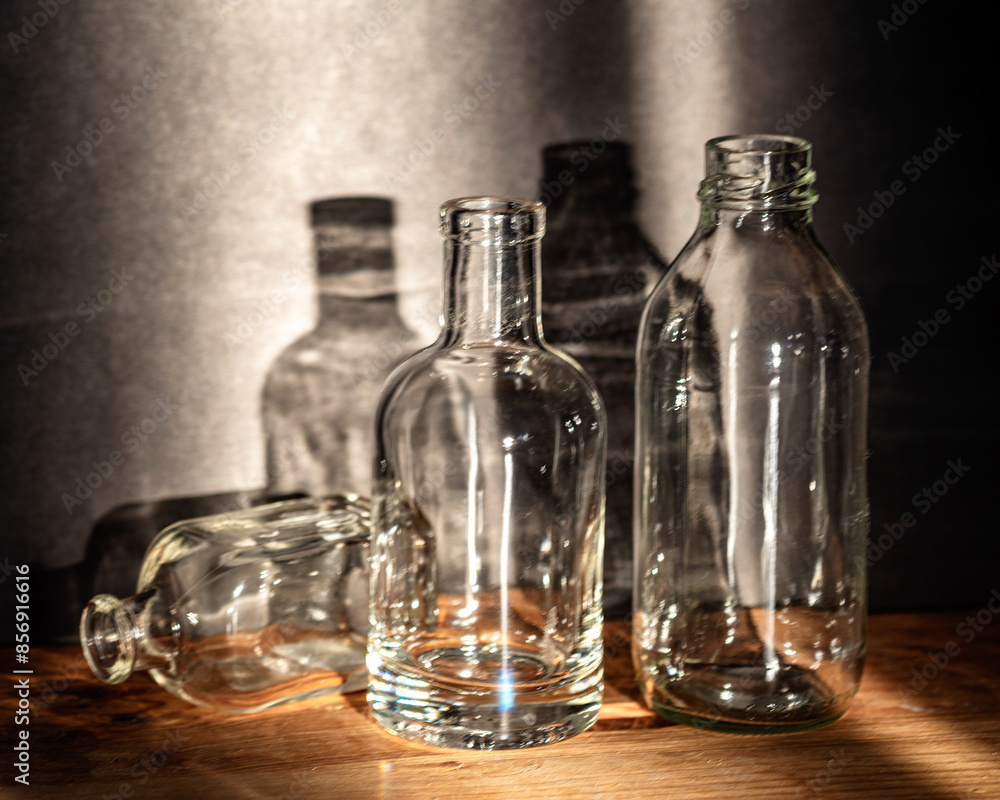 Still life with glass bottles, quiet shadows in the background, soft evening light Still life with glass bottles, quiet shadows in the background, soft evening light