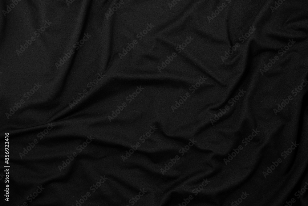 Fototapeta premium Rippled black fabric texture background. Cloth is wrinkled.