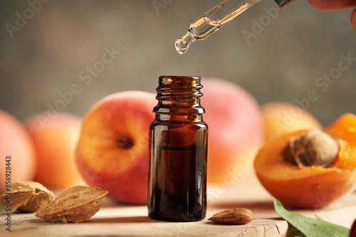 Photos Dropping apricot kernel oil into a glass bottle
