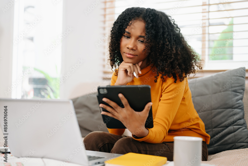Young woman relax on comfortable couch at home texting messaging on smartphone and tablet Young woman relax on comfortable couch at home texting messaging on smartphone and tablet