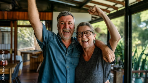 Winning success couple happy ecstatic celebrating being a winner. Dynamic energetic image of the couple, background modern house